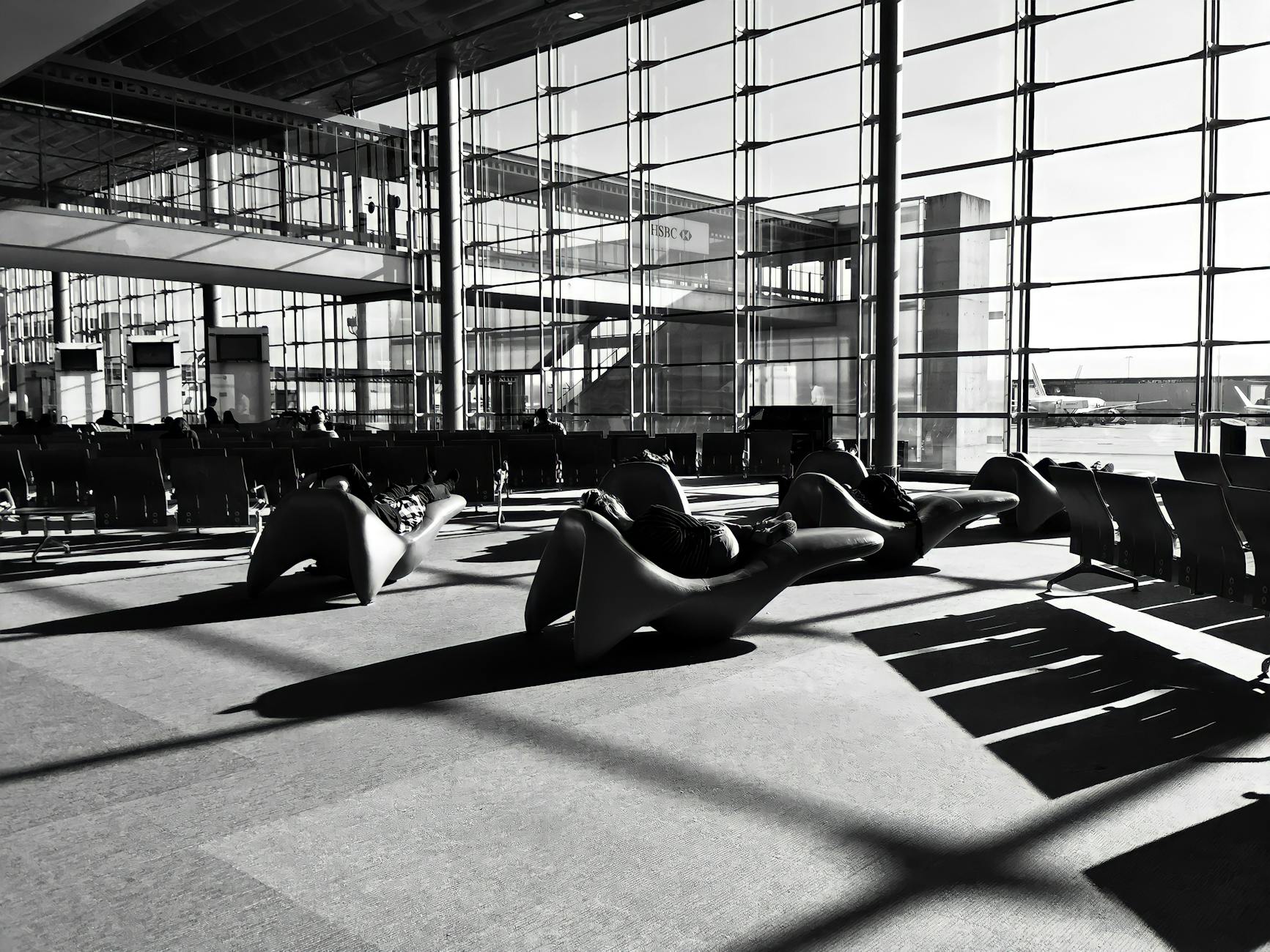 A modern airport lounge in Roissy-en-France, France, captured in monochrome with unique seating arrangements.